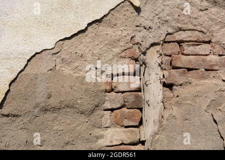 Old rustic home wall with red brick and dilapidated mortar. Close up and copy space Stock Photo