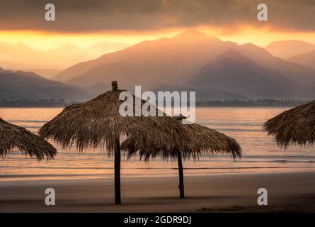 Sunrise over palapas on the Islitas Beach of the Pacific coast of Mexico near San Blas. Stock Photo