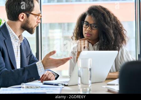Male mentor leader talking to female trainee at meeting in board room. Stock Photo