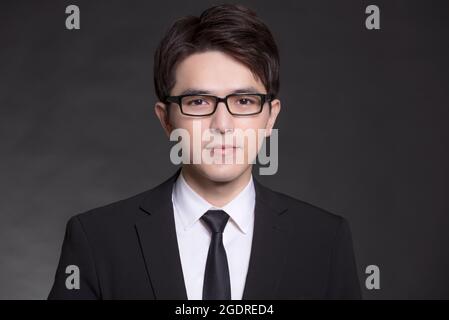 Young buisnessman in black suit and wearing eyeglasses Stock Photo
