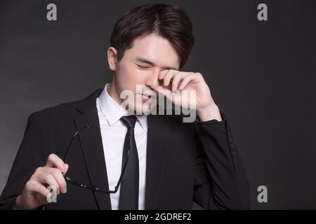 Business man feeling sick and tired. young man rubbing eyes Stock Photo