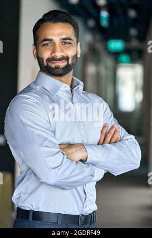 Smiling successful indian businessman looking at camera standing in office. Stock Photo