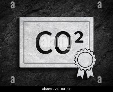 White co2 emissions trading symbol ETS license paper symbol on dark stone wall background Stock Photo