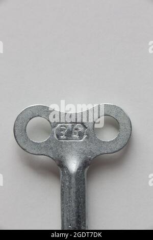 Macro of clockwork key on white background. Stock Photo