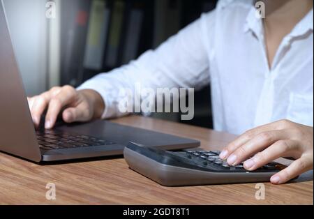 Accountant using calculator, counting, finance, taxes, fees, accounting, calculating, bills, money, planning, budget, loan, income and expenses, payme Stock Photo