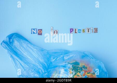 no to plastic words cut out of magazine. Flat lay, on a blue background. top view. plastic concept Stock Photo