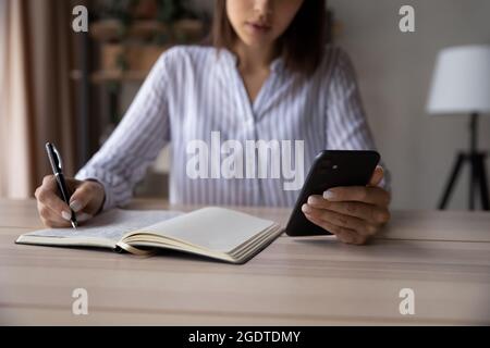 Close up of woman make notes using smartphone Stock Photo