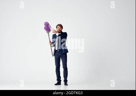 business man in a suit with a mop in his hands cleaning service Stock Photo