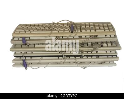 Stack of old worn keyboards isolated on white background. Stock Photo