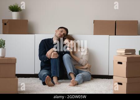 Upset spouses leave house sit on floor near cardboard boxes Stock Photo