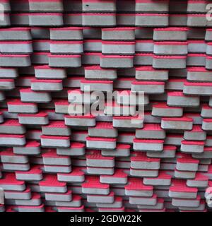 A stack of pink rubber tiles that fit together like giant puzzle pieces. Intended as temporary street cover to prevent children from injuring Stock Photo