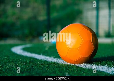 Orange soccer ball on the field of play Stock Photo