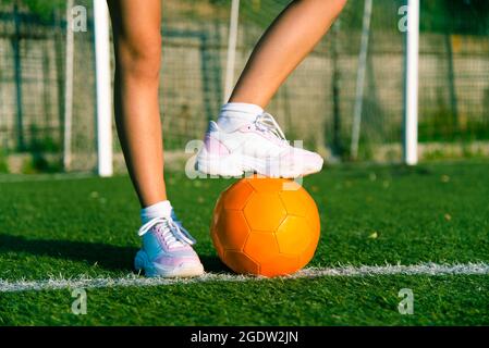 Girl foot stand on the ball, football player field match on stadium. Stock Photo