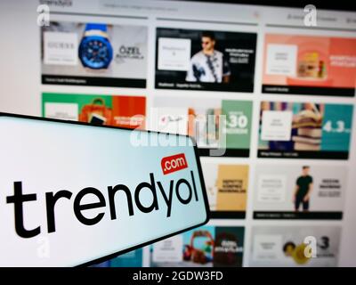 Smartphone with logo of Turkish online shopping platform Trendyol on screen in front of business website. Focus on center-right of phone display. Stock Photo