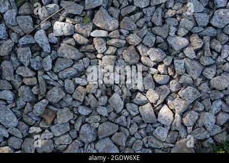 Real backround: grey crushed stones with sunbeam. Stock Photo