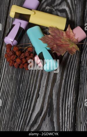 A set of colored markers for the school. They lie on pine boards. Nearby autumn maple leaves. Stock Photo