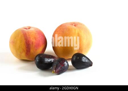 Horizontal photography with white background of two peaches and three figs from the organic garden. Stock Photo
