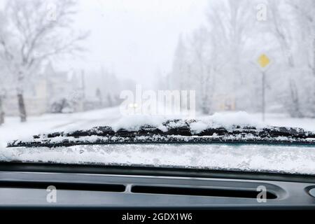 Road covered with snow seen through windshield.  Winter time Stock Photo