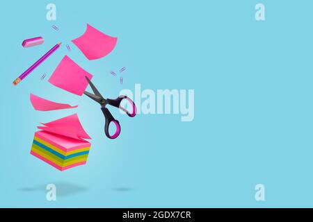 Creative idea made of notes, pieces of paper, pencil, eraser and scissors floating in the air. Levitating school supplies.Minimal, conceptual art. Cop Stock Photo