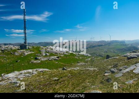 mobile phone cell tower over rural mountains in Europe (Norway), with windmills in background - Green Future concept Stock Photo