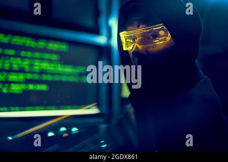 Cyber hacker breaks into databases to obtain information using a computer. Cybercrime and data security concept. Stock Photo