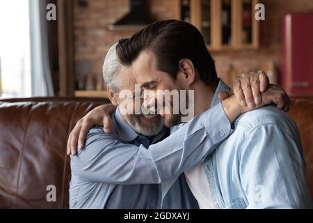 Loving mature dad hug adult grownup son Stock Photo