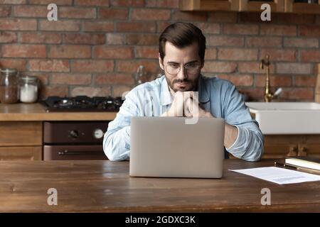 Pensive Caucasian man work on computer thinking Stock Photo