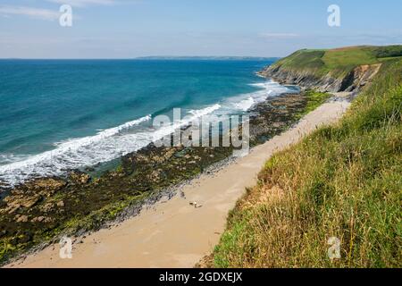 The South-West Coast Path above Porthbeor Beach on the Roseland Peninsula, Cornwall, UK Stock Photo