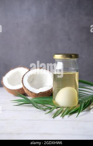 slice of fresh coconut and bottle of oil on a table  Stock Photo