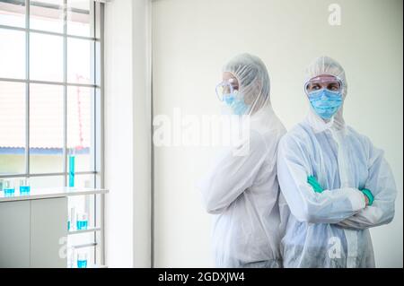 Couple male scientist wearing protection suit stand on the white background at laboratory. Scientist portrait shot Stock Photo