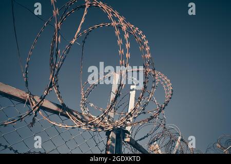 Barbed wire against dark blue evening sky Stock Photo