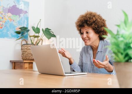 Senior african woman doing video call using laptop computer at home office - Focus on face Stock Photo