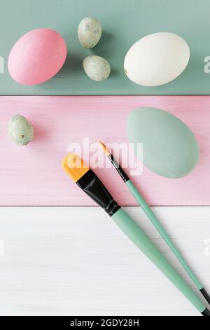 Painted Easter eggs and brushes on striped wooden background. Graphic resources Stock Photo