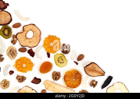 Above view of well laid out dried fruits apples, mango, orange, dried apricots, kiwi, dried coconut and walnuts on white background. Concept of organic healthy assorted dried fruit for snacks. Stock Photo