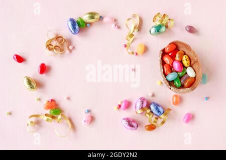 Chocolate Easter eggs and other sweets on pink background. Festive time Stock Photo