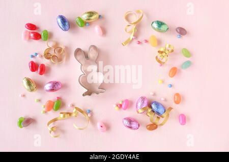 Chocolate Easter eggs and other sweets on pink background. Festive time Stock Photo