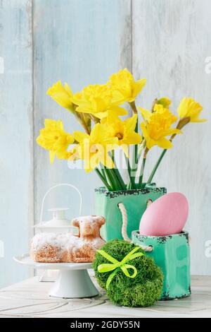 Easter table with lamb cake, bouquet of daffodils and painted eggs. Festive decor Stock Photo