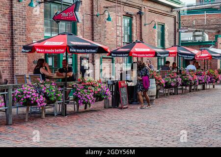 people sitting in outdoor patio at the toronto distillery district in the summer Stock Photo