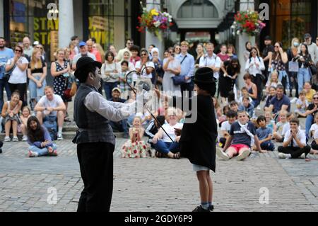 London, UK. 15th Aug, 2021. A street artist dressed as Charlie Chaplin performs in front of a crowd in London's Covent Garden. In the UK since 19th July most of the Covid restrictions lifted including mandatory face masks, social distance and public gatherings. (Credit Image: © Tayfun Salci/ZUMA Press Wire) Credit: ZUMA Press, Inc./Alamy Live News Stock Photo