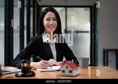 Business woman or legal advisor sitting wooden desk in office. Law, legal services, advice,Judge auction and real estate concept.