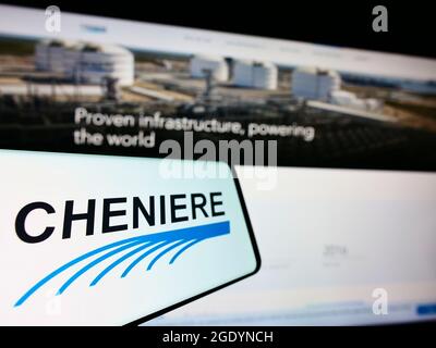 Cellphone with logo of American LNG company Cheniere Energy Inc. on screen in front of business website. Focus on center-left of phone display. Stock Photo