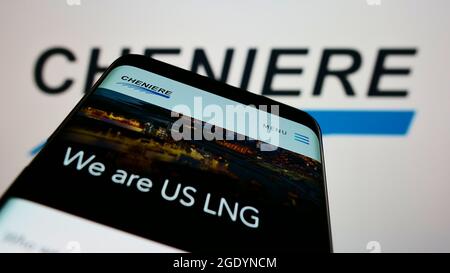 Smartphone with website of US LNG company Cheniere Energy Inc. on screen in front of business logo. Focus on top-left of phone display. Stock Photo