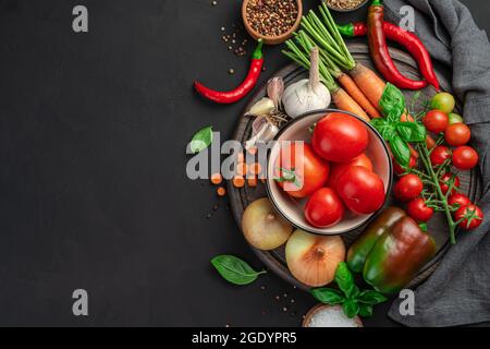 Fresh vegetables and spices on a cutting board on a black background. Stock Photo