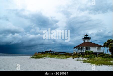 Port Boca Grande Lighthouse and Museum on Gasparilla Island as a tropical storm with black clouds looms off the coast in the Gulf of Mexico Stock Photo