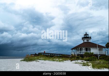 Port Boca Grande Lighthouse and Museum on Gasparilla Island as a tropical storm with black clouds looms off the coast in the Gulf of Mexico Stock Photo