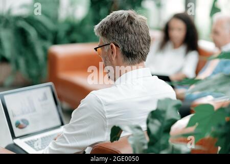 smiling businessman is working on a laptop in the office. Stock Photo