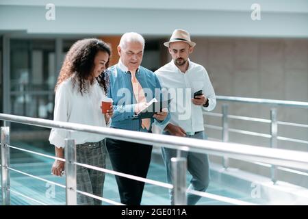 multinational business team with business documents walking through the office lobby. Stock Photo