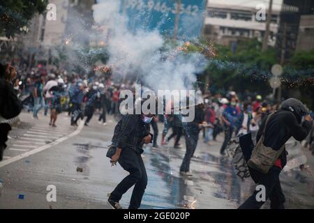 Bangkok, Thailand. 01st Jan, 2000. Protesters running for cover during clashes. Thai anti-government protesters clashed with police as they demonstrated against government's failure to handle the coronavirus outbreaks. (Photo by Adisorn Chabsungnoen/SOPA Images/Sipa USA) Credit: Sipa USA/Alamy Live News Stock Photo