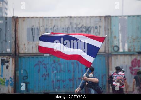 Bangkok, Thailand. 01st Jan, 2000. A protester waves the Thailand flag in front of a police water canon vehicle, during clashes. Thai anti-government protesters clashed with police as they demonstrated against government's failure to handle the coronavirus outbreaks. Credit: SOPA Images Limited/Alamy Live News Stock Photo