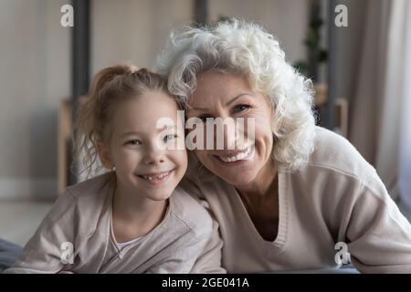 Portrait of happy old granny and small granddaughter relax together Stock Photo
